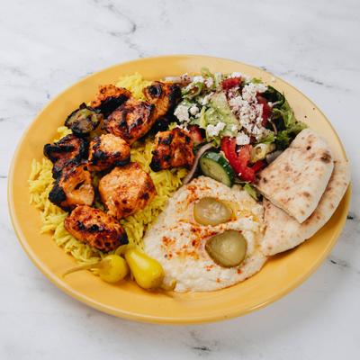 Shish Tawook served wover rice with sides of pita bread, hummus and a salad.