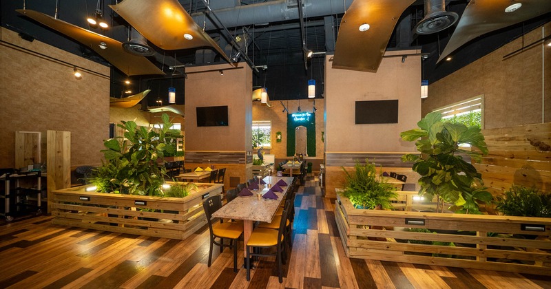 Interior with teal booths, marble tables, and lush plants