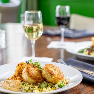 Carolina Crab Cakes with bacon fried sweet corn, a glass of white wine