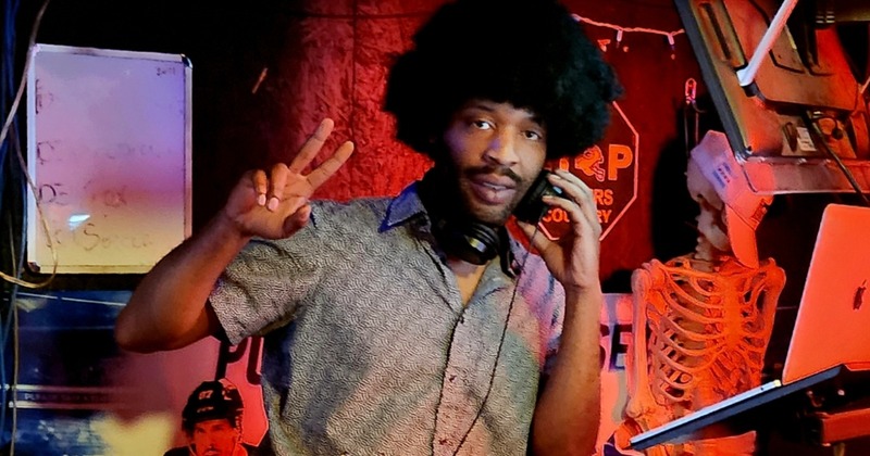 DJ poses with a peace sign while performing