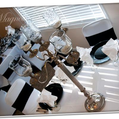 An elegant, multi-arm silver candelabra with glass hurricane candle holders.