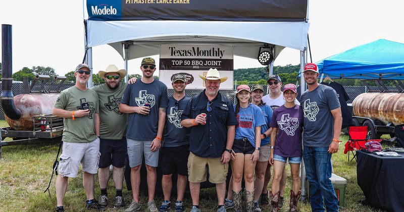 Outside, the owner and staff members standing in front of a tent