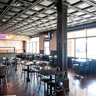 Intrior of a restaurant with tables, chairs, and booth seating.