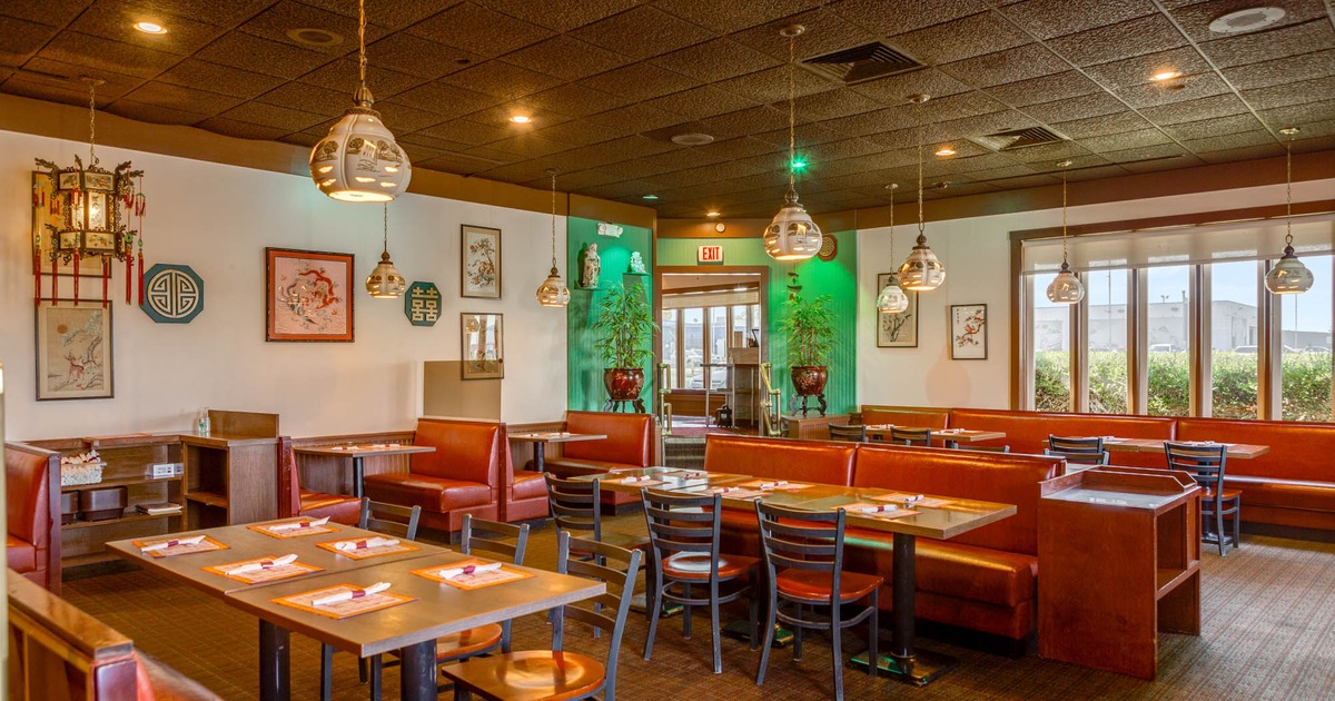 Interior, red leather padded seating booths with tables, ready for guests, oriental chandeliers