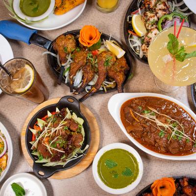 A variety of colorful North Indian dishes and drinks spread on a table.
