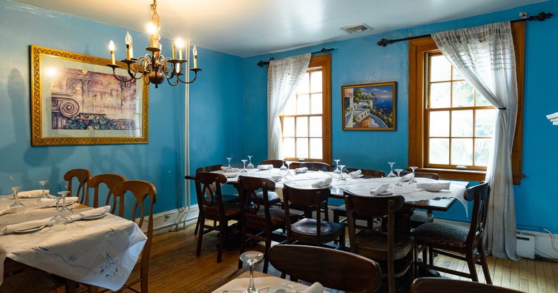 Vintage ambiance in a room with blue walls, hung pictures, and set tables