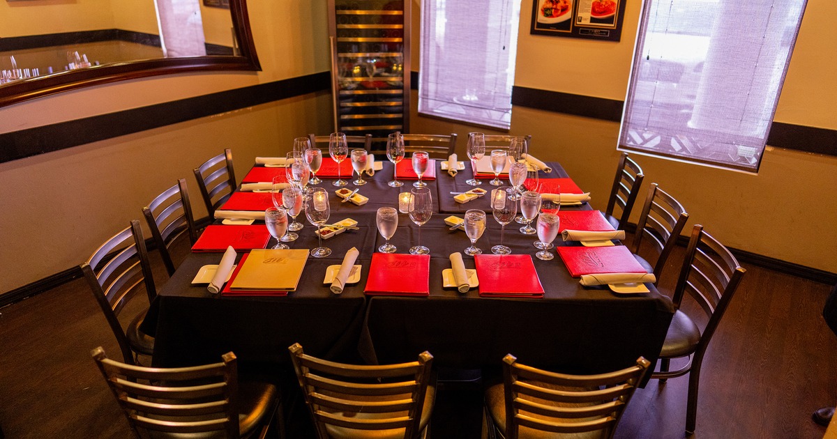 Private dining room with a large dining table elegantly set for twelve guests