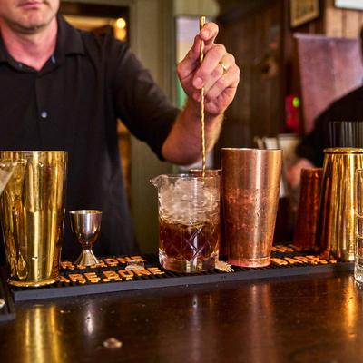 A bartender fixing a mixed drink.