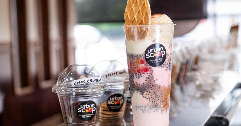 Pink layered dessert topped with ice cream and wafer