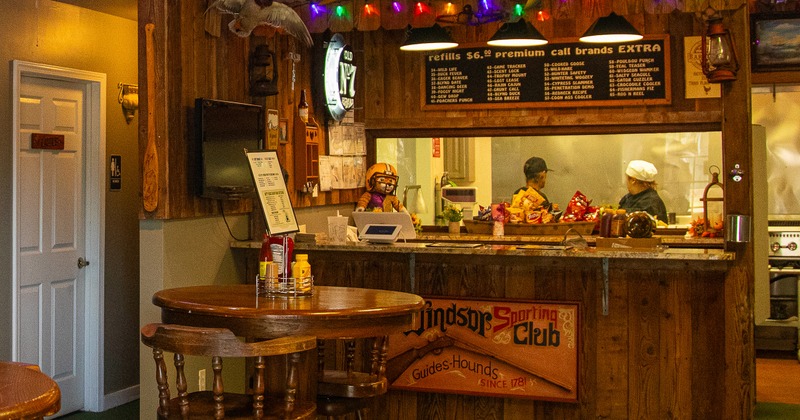 Wooden round high table with stools near the order counter