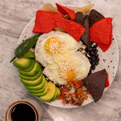 Huevos Rancheros plate and a cup of coffee, top view.