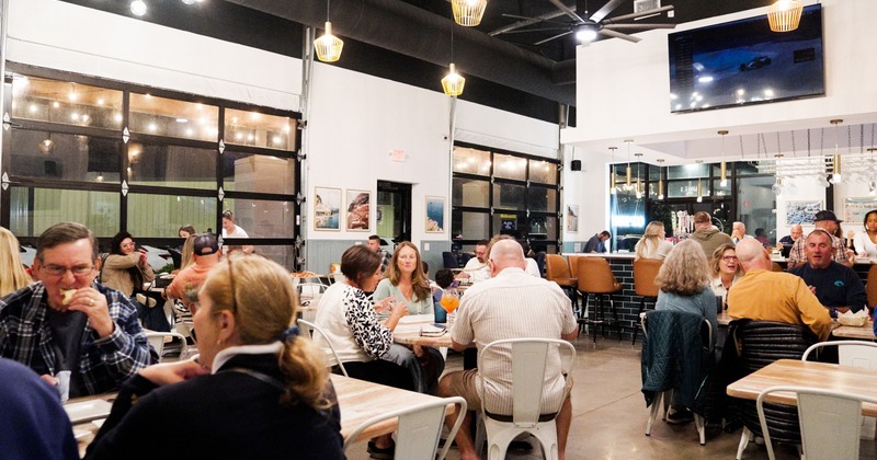 Interior space, bar and seating area with guests chatting and enjoying their food
