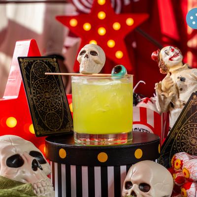 The Freak Show cocktail displayed amid Halloween-themed decor.