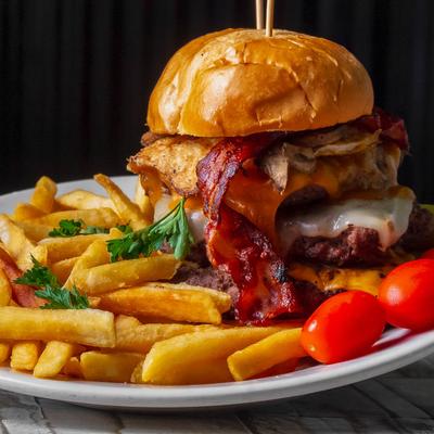 Double bacon cheeseburger with fries and grape tomatoes.