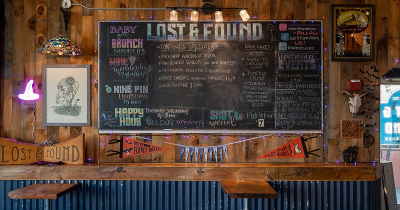 Tables with bar stools next to the decorated wall