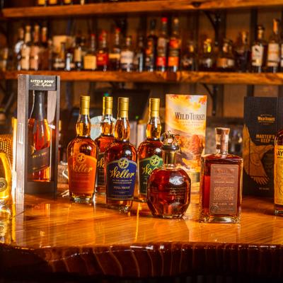 Assorted whisky bottles on a polished bar counter.