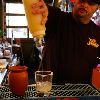 Bartender pouring a cocktail.
