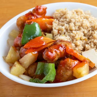 Sweet and Sour Chicken served with rice, bell peppers, and pineapple chunks.