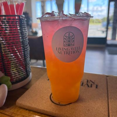 Iced beverage served in a clear plastic cup and placed on a cork coaster.