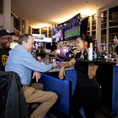 Bar ambiance, a server having lively conversation with guests.