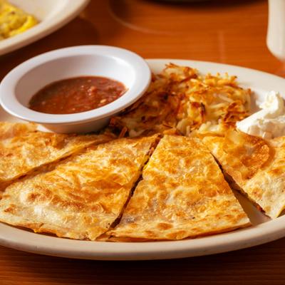 Breakfast Quesadilla served with hashbrowns, sour creme and a cup of salsa.