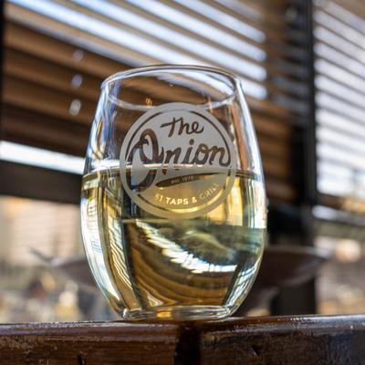 White wine in a stemless glass with the  Onions Bar and Grill logo.