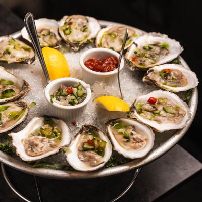 Fresh oysters served on a bed of ice with lemon weges and sauces.