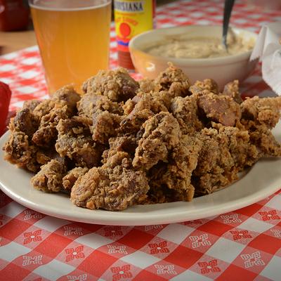 Fried chicken livers and gizzards served alongside mashed potatoes and a beer.