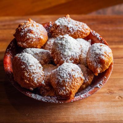 Fritters  topped with powdered sugar.