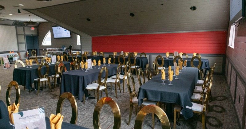 Interior, seating area, tables with gold painted chairs, ready for guests, slant roof