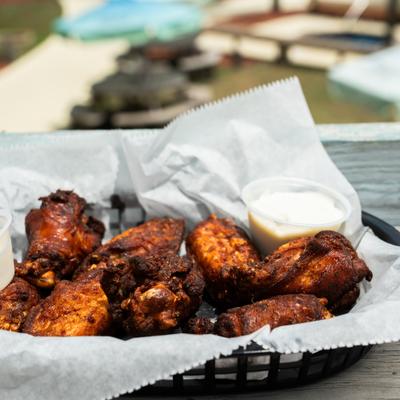 Barbecue wings in a paper-lined basket.