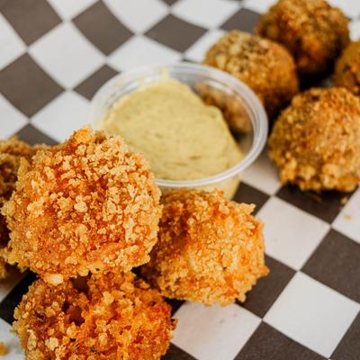 Crab bites with dipping sauce on checkered paper.