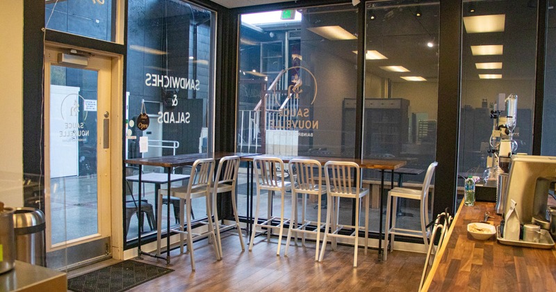 Interior, high seating tables with stools, restaurant entrance, large shop windows