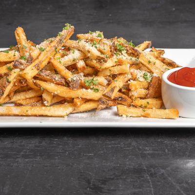 Plate of truffle fries served with dipping sauce.