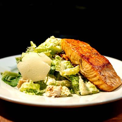 Caesar salad with a salmon filet.