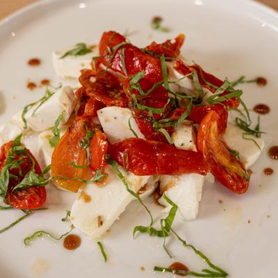 Mozzarella Caprese salad, with slow roasted tomatoes, basil, and olive oil.