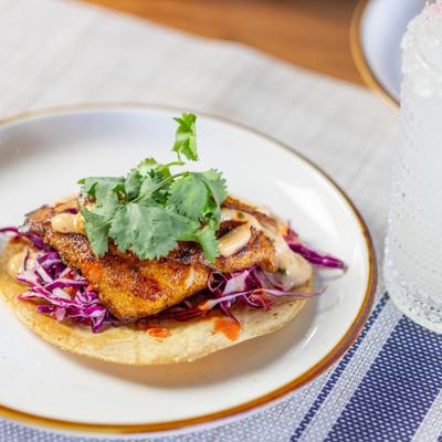 Grilled fish taco with cabbage slaw and cilantro.