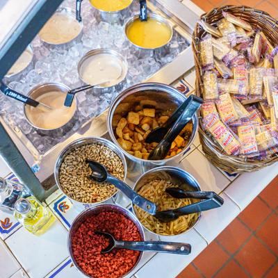 Various toppings and a basket of crackers.