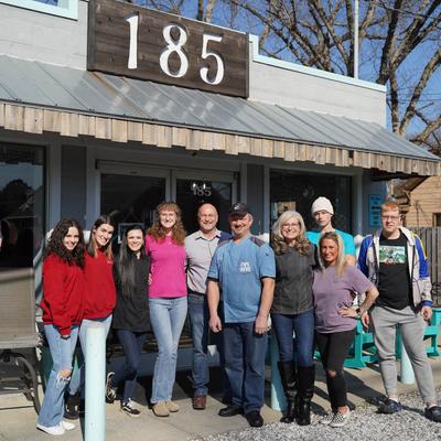 The owners posing with staff in front of the restaurant.