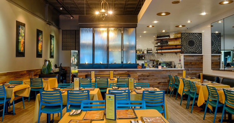Interior, tables and chairs in dining area with bar in the back
