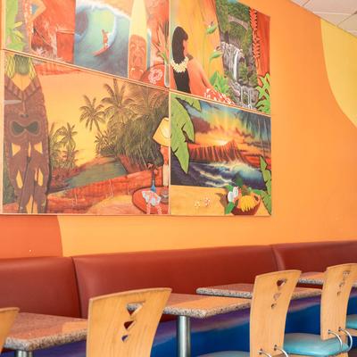 Interior with orange walls, featuring tropical-themed murals and serene beach scenes.