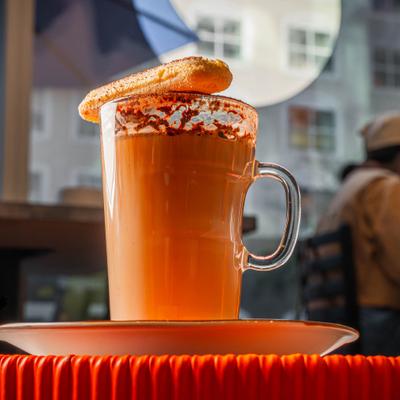 Hot latte drink with a cookie on top of the mug.