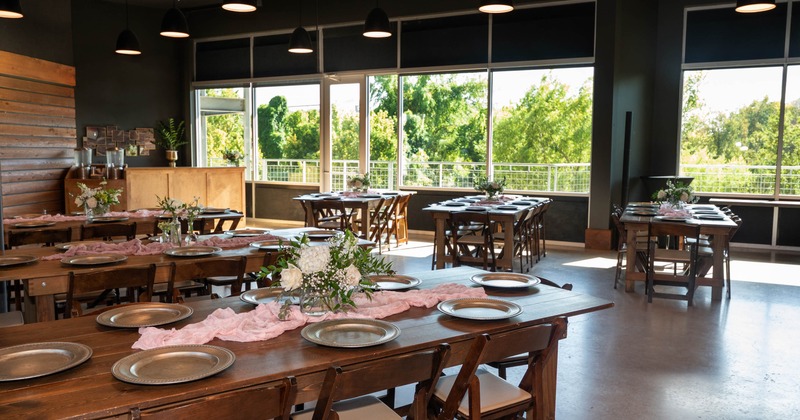 Interior of the Urban Creekside event center, set up and decorated tables with chairs,