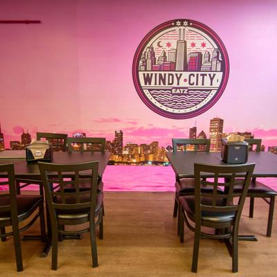 Intrerior with tables, chairs and restaurant's sign.