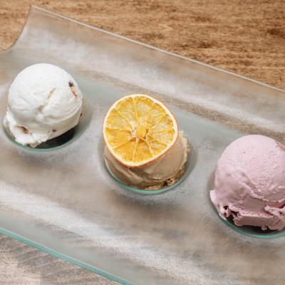 Tasting flight with three distinct scoops of ice cream served on a glass tray.