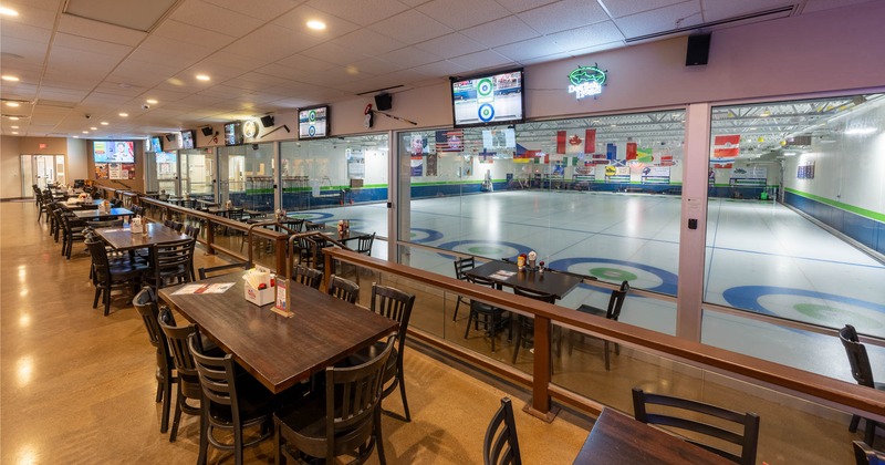 Dining tables next to windows overlooking the sports game room