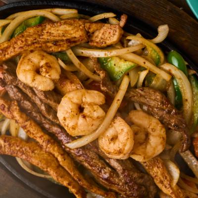 Close-up of chicken, shrimp, and steak fajitas.
