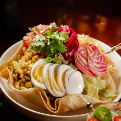 South West Taco Salad topped with guacamole, corn, boiled eggs and mixed cheese.