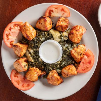 Seasoned chicken served with sauteed spinach and tomatoes.