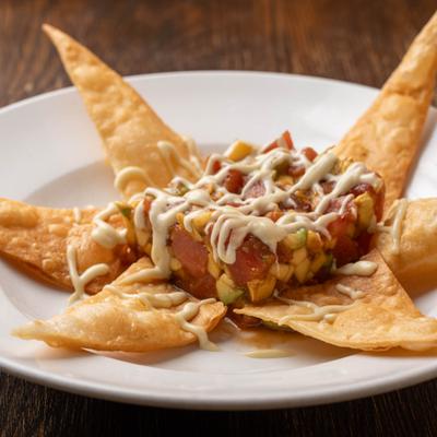 Tuna tostadas drizzled with sauce and served on the plate.